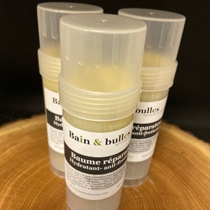 May include: Three white plastic tubes of a moisturizing balm with the text "Bain & bulles Savonnerie" and "Baume r&eacute;parateur Hydratant- anti-frottement" on the label. The balm is a light yellow color.