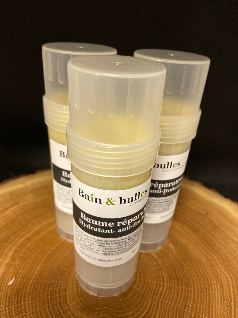 May include: Three white plastic tubes of a moisturizing balm with the text "Bain & bulles Savonnerie" and "Baume r&eacute;parateur Hydratant- anti-frottement" on the label. The balm is a light yellow color.