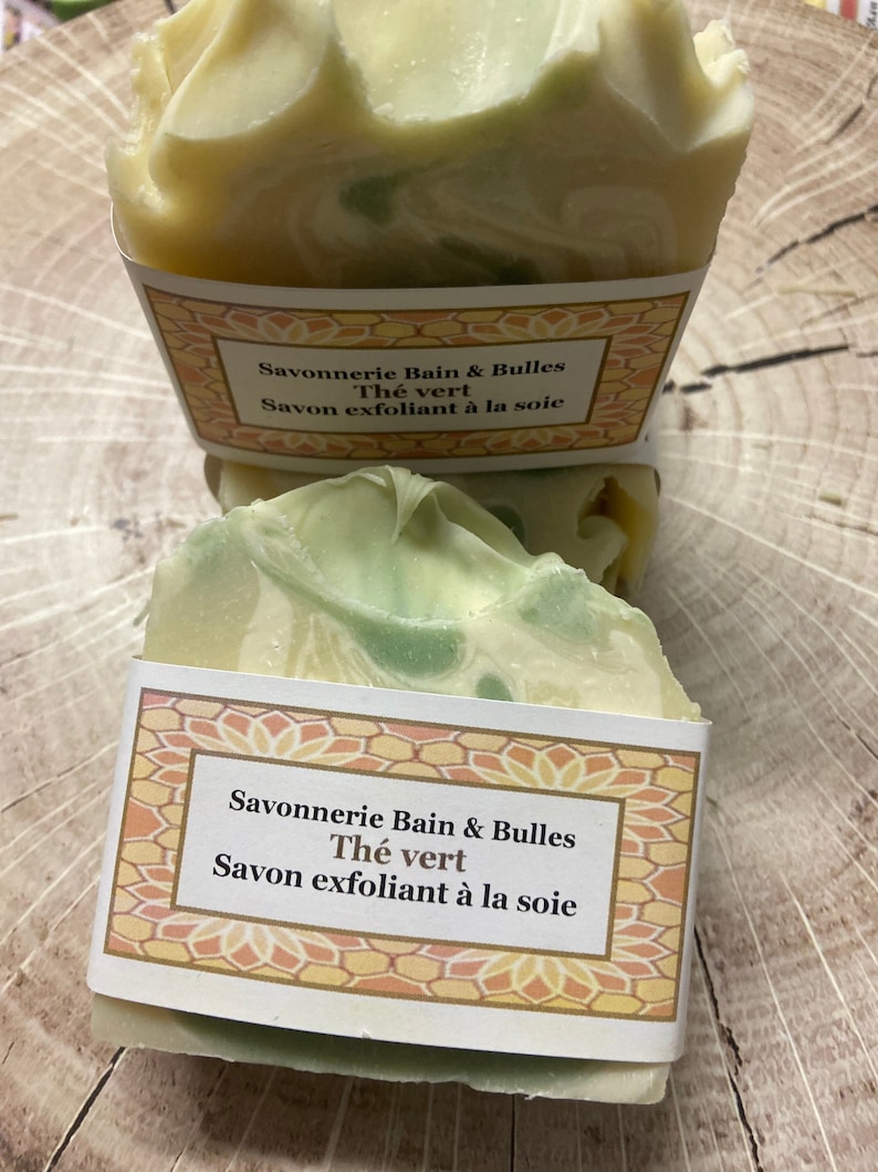 May include: Two bars of green tea scented soap with a white and green swirl pattern. The soap is wrapped in a label that reads "Savonnerie Bain & Bulles Th&eacute; vert Savon exfoliant &agrave; la soie".