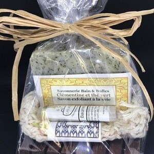 Puede incluir: Un set de regalo que contiene una barra de jab&oacute;n verde, una peque&ntilde;a botella de b&aacute;lsamo, una esponja natural de luffa y un jabonera de madera. El jab&oacute;n est&aacute; etiquetado con "Savonnerie Bain & Bulles Cl&eacute;mentine et th&eacute; vert Savon exfoliant &agrave; la soie".