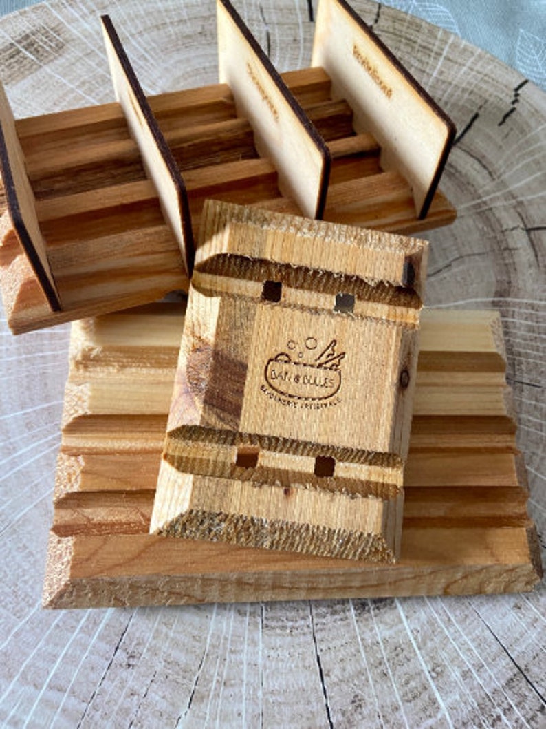 Puede incluir: Jabonera de madera con un dise&ntilde;o en relieve y un logotipo que dice "Bar & Bolles, Exquisite Originals".