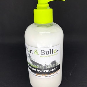 May include: A white bottle with a green pump dispenser and a black and white label that reads "Bain & Bulles Savonnerie artisanale Creme hydratante peau seche".
