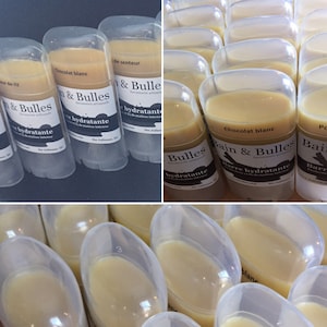 May include: A close-up of several clear plastic tubes filled with a white, creamy substance. The tubes are labeled "Bain & Bulles Savonnerie artisanale Barre hydratante" and "Chocolat blanc".