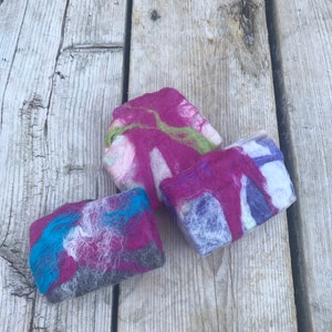 May include: Three handmade soap bars with a colorful, marbled design. The soap bars are made with natural ingredients and are perfect for sensitive skin.