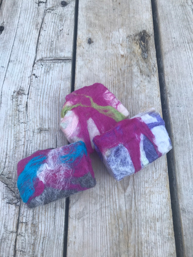 May include: Three handmade soap bars with a colorful, marbled design. The soap bars are made with natural ingredients and are perfect for sensitive skin.