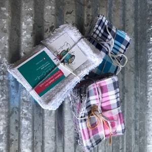 Op de afbeelding: Drie sets herbruikbare make-up remover pads, gebonden met touw. De pads zijn gemaakt van verschillende stoffen, waaronder wit badstof, blauw-wit geruit en roze-wit geruit. De sets zijn verpakt met een visitekaartje waarop staat "Creation Tha", "Cr&eacute;ations uniques faites de tissus r&eacute;cup&eacute;r&eacute;s et neufs", "Nathalie Croneller", "514.312.4245", "Thale4@hotmall.com", "Information Sale".