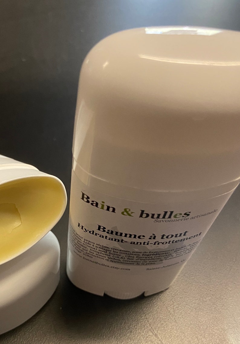 May include: A white deodorant stick with a green and black label that reads "Bain & bulles Savonnerie artisanale Baume &agrave; tout Hydratant-anti-frottement" and a website address.