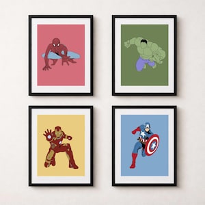 May include: Four framed art prints featuring superhero illustrations. Spider-Man in red and blue on a pink background, Hulk in green and purple on a green background, Iron Man in red and gold on yellow, and Captain America on blue.
