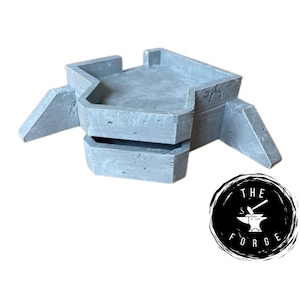 Op de afbeelding: Een grijs betonnen bunkermodel met een plat dak en twee zijwanden. De bunker heeft een getextureerd oppervlak en is ontworpen voor tabletop gaming.