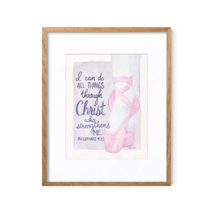 May include: Watercolor art print in a wooden frame. The artwork features a pink ballet shoe with ribbons and the text "I can do all things through Christ who strengthens me." The quote is from Philippians 4:13.