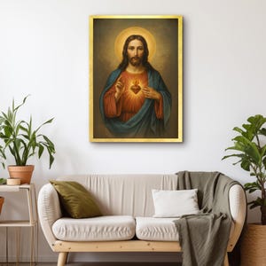 May include: A framed religious portrait of Jesus Christ, depicted with a halo and a glowing heart. The artwork features a gold frame and is displayed on a white wall above a beige sofa. The painting's colors include red, blue, and gold.
