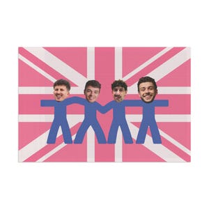 May include: A canvas print with a pink and white Union Jack design. Four blue figures are linked together, each with a person's face. The print has a modern, graphic design, suitable for wall decor.