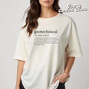 May include: Ivory-colored t-shirt with the word "geotechnical" and its definition printed in black. The shirt has short sleeves and a relaxed fit. The text "Ivory Comfort Colors" is printed in a cursive font at the top right.