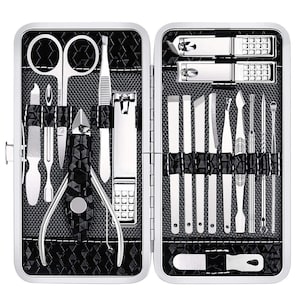 May include: A silver manicure set in a black and silver case. The set includes nail clippers, scissors, cuticle pushers, nail files, and other grooming tools. The case is open, displaying the tools neatly arranged against a textured background.