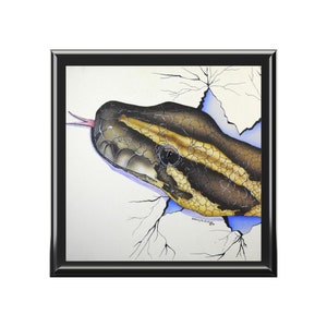 Może przedstawiać: Akwarela przedstawiająca głowę węża wyłaniającą się z pękniętej ściany. Wąż jest brązowy i żółty z czarnym okiem. Ściana jest biała z niebieskimi i szarymi pęknięciami.