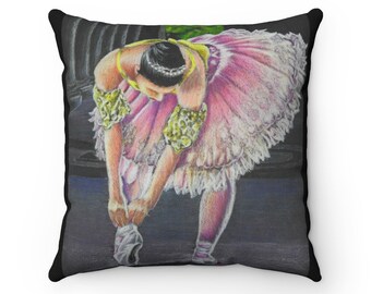 Puede incluir: Una bailarina en un tutú rosa con un corpiño amarillo y dorado está atándose las zapatillas de ballet. El fondo es gris oscuro.