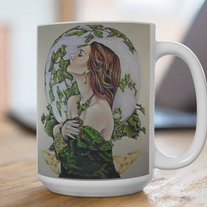 Puede incluir: Taza de cerámica blanca con un diseño verde y dorado. El diseño presenta a una mujer con cabello rojo y ojos verdes, vestida con un vestido verde y un collar dorado. Está rodeada de hojas verdes y un nudo celta.