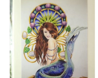 May include: A mermaid with long brown hair and a blue tail sits on a sandy beach. She is wearing a pearl necklace and has a crown of purple and gold above her head.