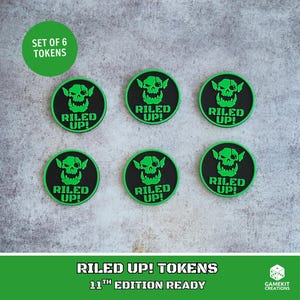 May include: A set of six circular tokens featuring a black background with a bright green graphic of an orc skull and the text RILED UP! in bold green letters. The tokens are arranged in two rows of three, displaying a consistent design.