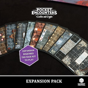 以下が含まれることがあります： Pocket Encounters: Castles and Crypts の拡張パック。ダンジョンや城のレイアウトが詳細に描かれたゲームカードがいくつか表示されています。カードは扇状に広げられ、「Expansion requires the base kit to play」と書かれた紫色の六角形のラベルが付いています。