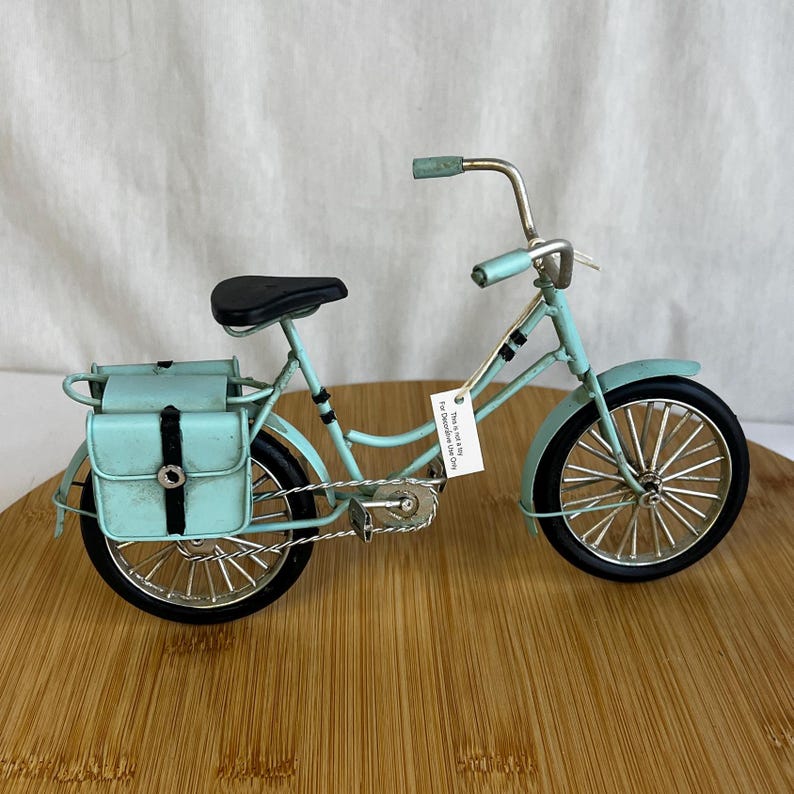teal blue metal messenger bicycle with two metal messengers bags on the back