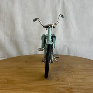 teal blue metal messenger bicycle with two metal messengers bags on the back