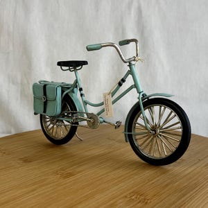 teal blue metal messenger bicycle with two metal messengers bags on the back
