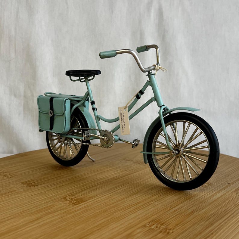 teal blue metal messenger bicycle with two metal messengers bags on the back