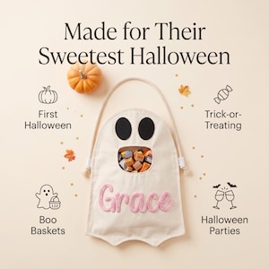 Puede incluir: Una bolsa de lona color crema con forma de fantasma, asa de cuerda, dos ojos de fieltro negro y una abertura central llena de dulces. El nombre Grace est&aacute; bordado en hilo rosa en la parte frontal. El texto dice Made for Their Sweetest Halloween.