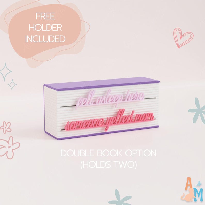 May include: A double book-shaped holder with a purple top and bottom and white pages. The holder has two lines of text: "fell asleep here" and "someone yelled mom." The text "FREE HOLDER INCLUDED" and "DOUBLE BOOK OPTION (HOLDS TWO)" are also visible.