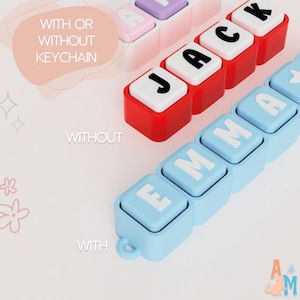 May include: Three rows of square, block-style letter beads arranged to spell names. One row is red with white blocks spelling JACK, one is light blue with white blocks spelling EMMA, and one is white with pink blocks spelling a name.