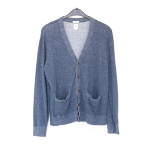 Könnte beinhalten: Blauer Cardigan mit V-Ausschnitt und zwei Vordertaschen. Der Pullover hat einen Knopfverschluss und hängt an einem schwarzen Kleiderbügel. Das Gap-Logo ist auf der Rückseite des Kragens sichtbar.