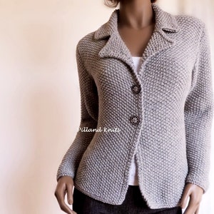 May include: A gray knitted cardigan with a collar and button closure. The cardigan has a textured knit pattern and is fitted.