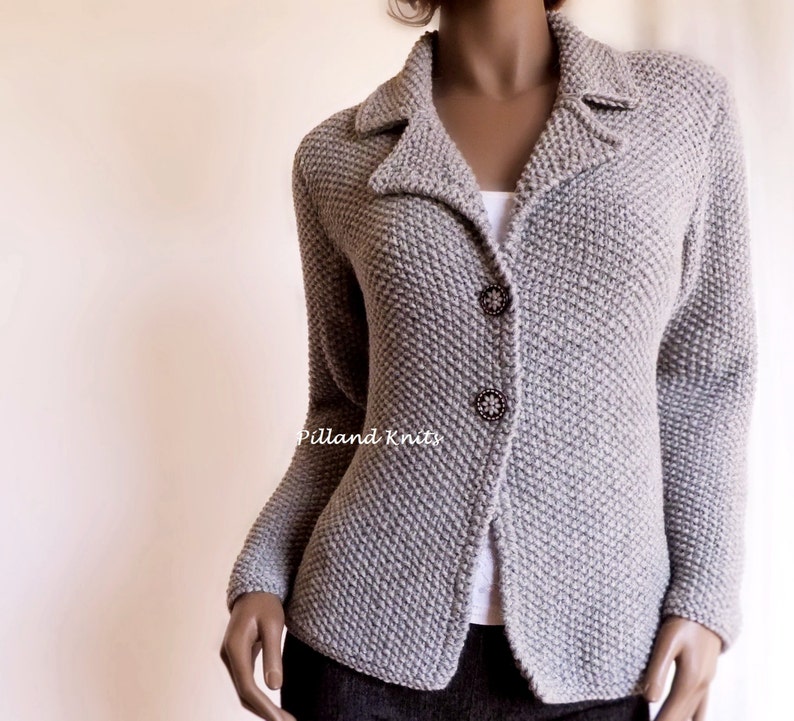 May include: A gray knitted cardigan with a collar and button closure. The cardigan has a textured knit pattern and is fitted.