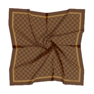 May include: A brown silk scarf with a gold geometric pattern and a brown border. The scarf is folded and the text "HAMPTONS NY" is visible in the bottom right corner.