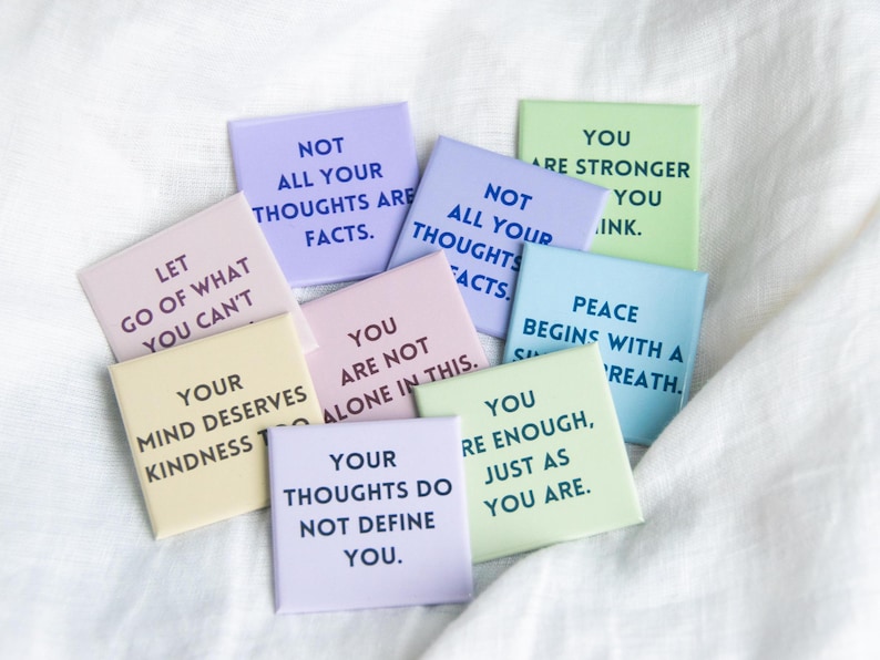 May include: A set of colourful square magnets with positive affirmations printed on them. The magnets feature phrases like "Let go of what you can't", "Your mind deserves kindness", "Not all your thoughts are facts", "You are not alone in this", "Your thoughts do not define you", "Peace begins with a breath", and "You are stronger than you think".