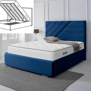 May include: A blue upholstered bed with a tufted headboard and a white mattress. The bed has a storage compartment. The bed is set on a grey rug. A lamp and side table are on the right.