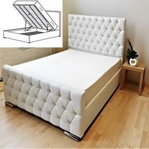May include: White upholstered bed frame with a tufted headboard and a storage compartment underneath. The bed frame has a diamond-shaped pattern and is accented with crystal-like buttons.