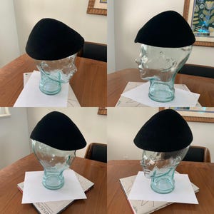 May include: Four black felt hats on mannequin heads. The hats are all the same style, with a rounded crown and a brim that curves down around the head. The hats are displayed on white paper backgrounds.