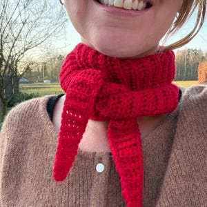May include: A white ceramic mug with a black handle and the text "But First, Coffee" in a bold, black font. The mug is set against a blurred background, highlighting its clean design.