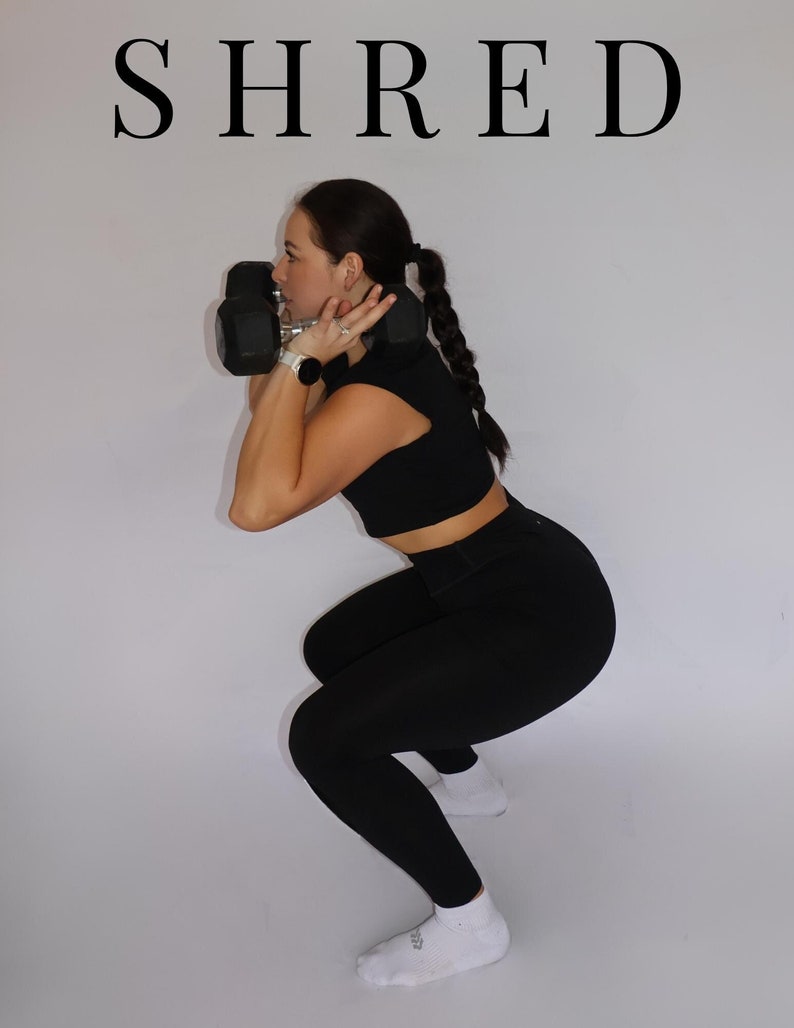 May include: A woman wearing black leggings and a black crop top is doing a squat while holding two black dumbbells.