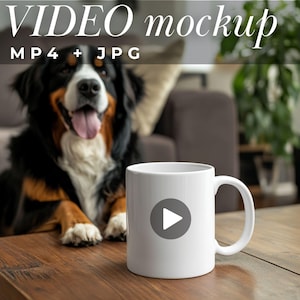 Könnte beinhalten: Weiße Keramiktasse mit einem grauen Wiedergabe-Button-Grafik. Die Tasse steht auf einem Holztisch, im Hintergrund ist ein Berner Sennenhund zu sehen. Der Text "VIDEO mockup" und "MP4 + JPG" ist ebenfalls zu sehen.