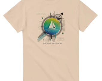 May include: A beige t-shirt featuring a graphic of a sailboat on the water within a circular design. The design includes a compass, geometric lines, and the phrases "Chasing Horizons" and "Finding Freedom."