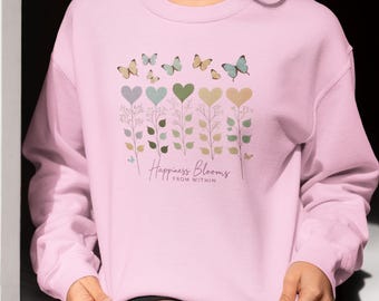 May include: Pink sweatshirt with a graphic of butterflies and flowers with the text "Happiness Blooms From Within".