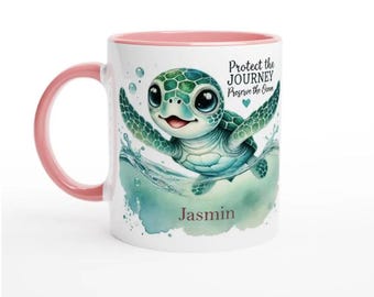 May include: A white ceramic mug with a pink rim features a cartoon sea turtle swimming in blue water. The mug has the text "Protect the Journey Preserve the Ocean" and the name "Jasmin" printed on it.