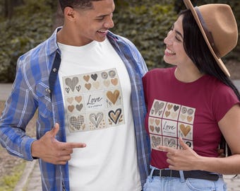 May include: White t-shirt with a square design of various heart illustrations in black, brown, and beige, with the text "Love is a Lifestyle." A person is wearing a blue plaid shirt. Another person is wearing a burgundy t-shirt with the same design.