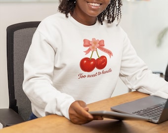 May include: White sweatshirt with a cherry graphic and the text "Kiss of Flavor" and "Too sweet to handle".