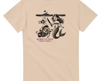 May include: A beige t-shirt with a black and white illustration of a scuba diver being chased by a mermaid with a knife. The text "Born to Dive" and "Forced to Surface" is printed below the illustration.