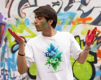 May include: A white t-shirt with a colorful graphic design that says "Think Go". The graphic is a blue, green, and white splatter design. The shirt is being worn by a person with red paint on their hands.