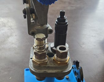 May include: A blue reloading press with a blue dial numbered 1 to 9. The press is mounted on a blue base with the text "Dillon Precision" printed on it.
